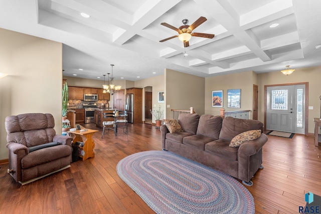 living room featuring wood-type flooring, arched walkways, coffered ceiling, and beamed ceiling