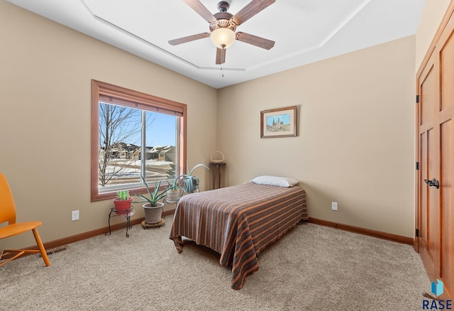 bedroom with light carpet, ceiling fan, visible vents, and baseboards