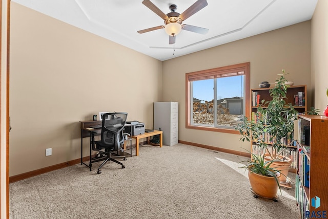 carpeted office featuring a ceiling fan, visible vents, and baseboards