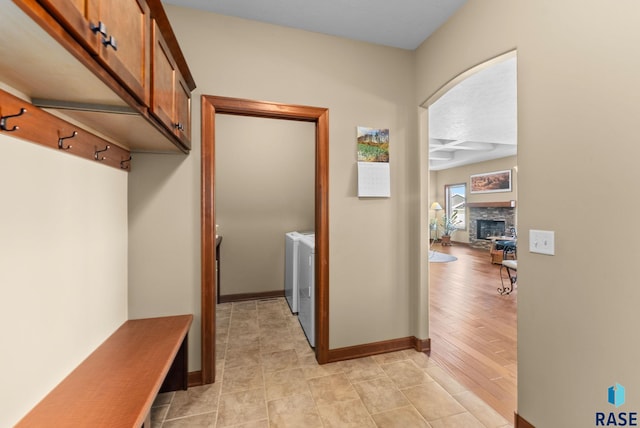 mudroom featuring a fireplace, independent washer and dryer, and baseboards