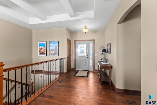 entryway featuring beam ceiling, baseboards, and hardwood / wood-style flooring