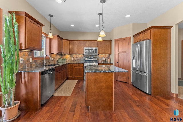 kitchen featuring dark wood-style floors, a kitchen island, brown cabinets, stainless steel appliances, and a sink