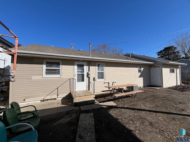 rear view of house with roof with shingles