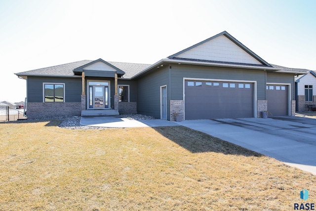 view of front of house with an attached garage, concrete driveway, and a front yard