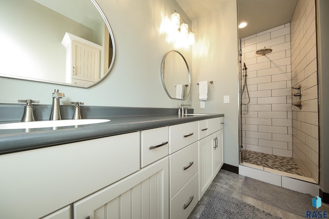 full bathroom featuring double vanity, a stall shower, and a sink