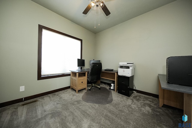 office space featuring baseboards, visible vents, dark colored carpet, and a ceiling fan