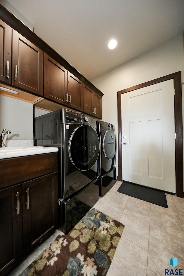 laundry area with light tile patterned floors, recessed lighting, a sink, independent washer and dryer, and cabinet space