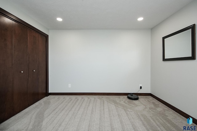 unfurnished bedroom featuring light carpet, recessed lighting, and baseboards