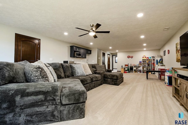 living room featuring carpet floors, ceiling fan, a textured ceiling, and recessed lighting