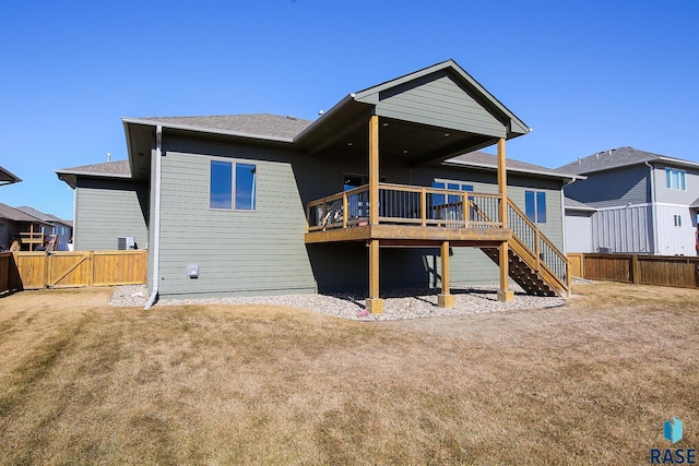 back of property featuring a lawn, stairway, a gate, fence, and a deck