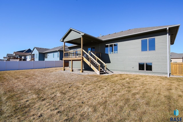 rear view of property with a yard, fence, stairway, and a deck