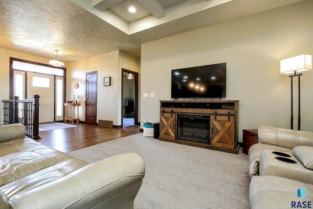 living area with visible vents, baseboards, a glass covered fireplace, dark wood-style flooring, and recessed lighting