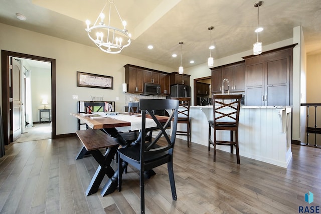 dining area with a chandelier, recessed lighting, baseboards, and wood finished floors