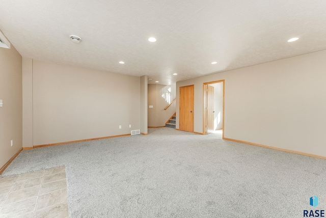 unfurnished room with light carpet, stairway, and baseboards