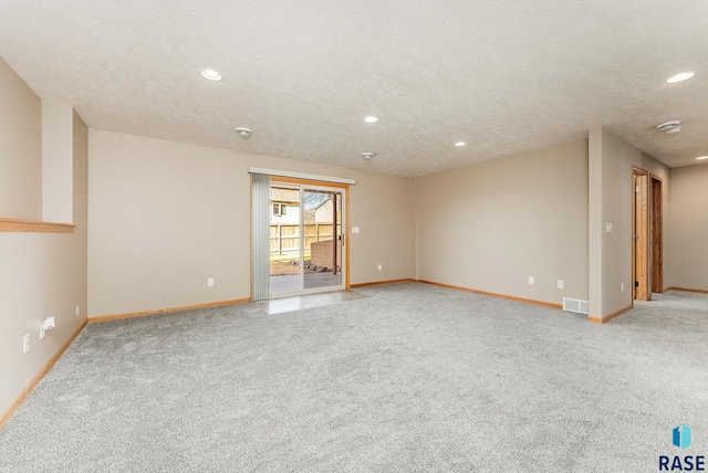 empty room featuring recessed lighting, light colored carpet, visible vents, and baseboards