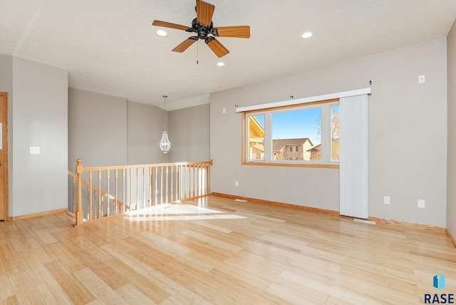 spare room with light wood finished floors, baseboards, and recessed lighting