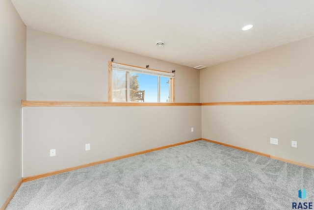 unfurnished room featuring carpet and baseboards