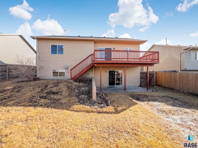 back of house featuring a deck, a patio area, a fenced backyard, and stairs