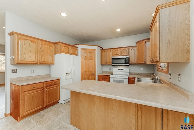 kitchen with recessed lighting, a peninsula, white appliances, a sink, and light countertops