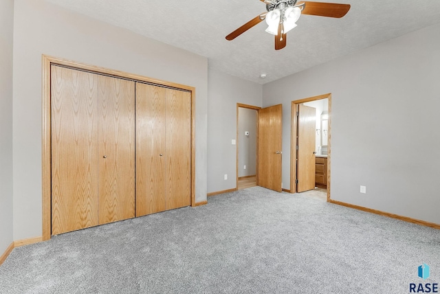 unfurnished bedroom with a closet, light carpet, a textured ceiling, and baseboards