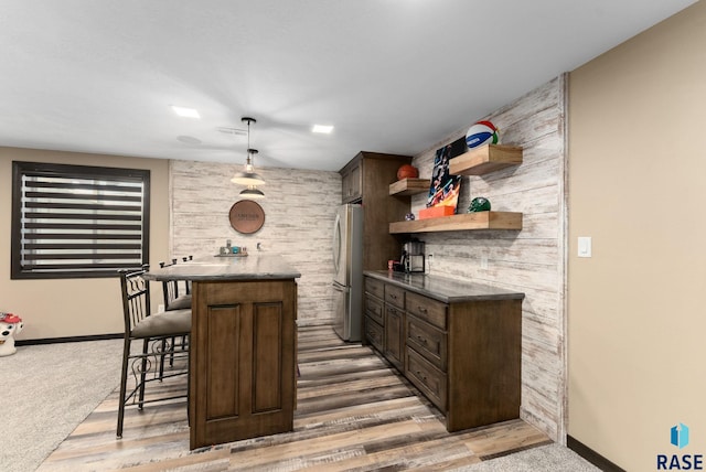 bar featuring baseboards, carpet, freestanding refrigerator, and pendant lighting