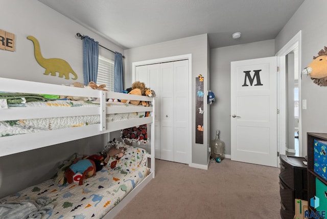 bedroom featuring light carpet, baseboards, and a closet