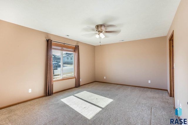 unfurnished room featuring light colored carpet, ceiling fan, visible vents, and baseboards