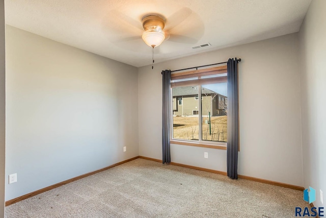 unfurnished room with light carpet, ceiling fan, visible vents, and baseboards