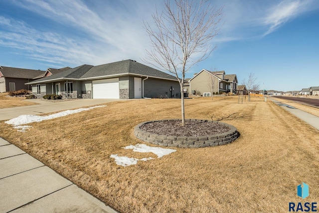 view of home's exterior with driveway, a garage, stone siding, a residential view, and a yard