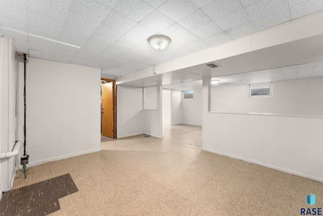 below grade area featuring light floors and baseboards