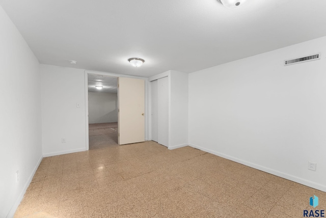 empty room featuring visible vents, baseboards, and tile patterned floors