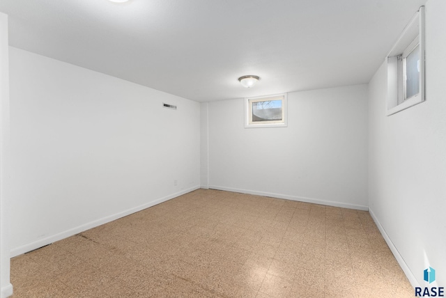 basement with visible vents, baseboards, and tile patterned floors