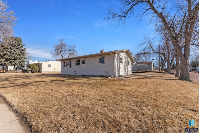 view of front facade with a front lawn and a chimney