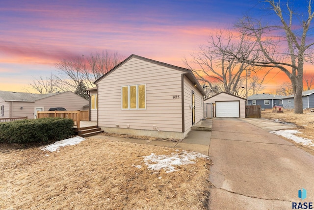 view of front of house with driveway, a garage, a deck, and an outdoor structure