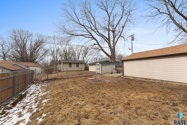 view of yard with an outbuilding, a storage unit, and a fenced backyard