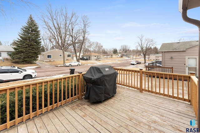 wooden terrace with a residential view and grilling area