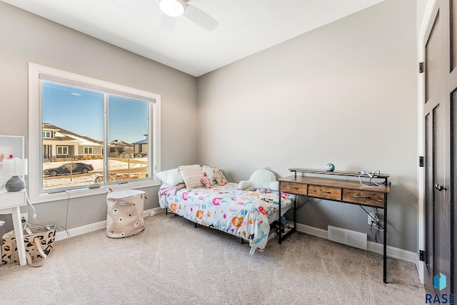 carpeted bedroom featuring a ceiling fan, visible vents, and baseboards