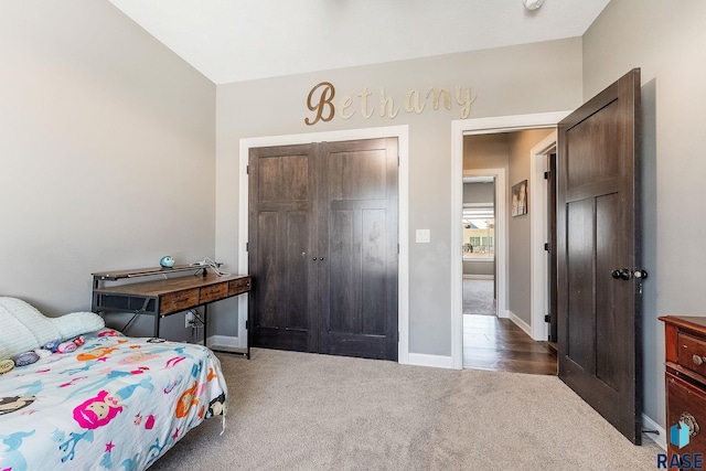 bedroom featuring a closet, dark carpet, and baseboards