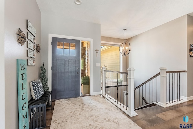 entryway featuring baseboards and a chandelier