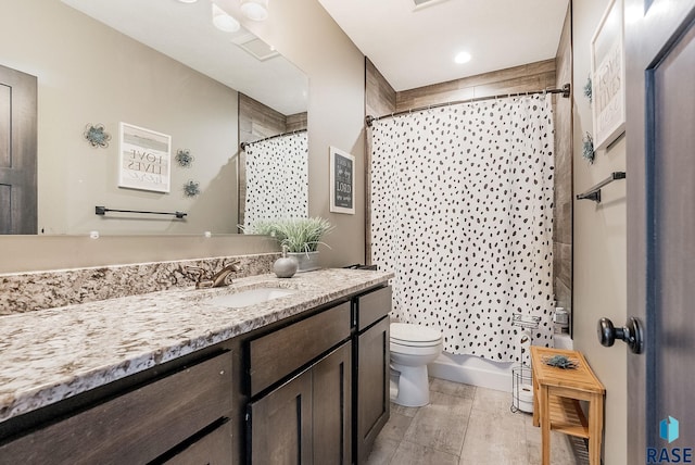 full bathroom with shower / bath combo with shower curtain, vanity, and toilet