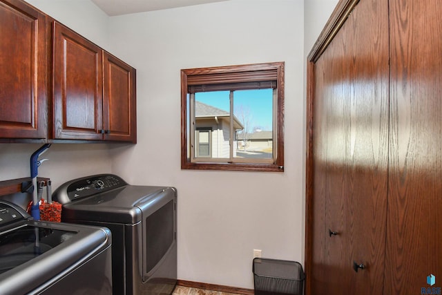 laundry area featuring washer and dryer, cabinet space, and baseboards