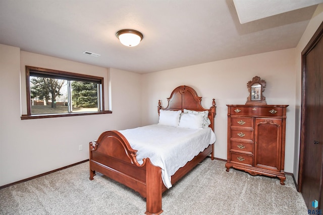 bedroom with baseboards, visible vents, and light colored carpet