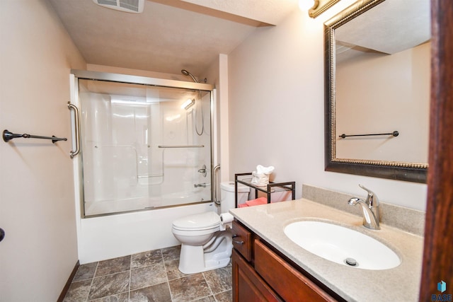 full bathroom featuring visible vents, combined bath / shower with glass door, vanity, and toilet