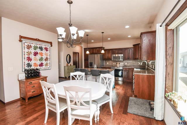 dining space featuring baseboards, recessed lighting, dark wood finished floors, and an inviting chandelier