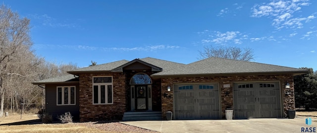 view of front of house with an attached garage, a shingled roof, and concrete driveway