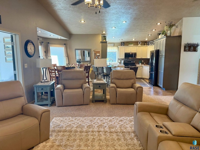 living area featuring a textured ceiling, ceiling fan, lofted ceiling, and recessed lighting