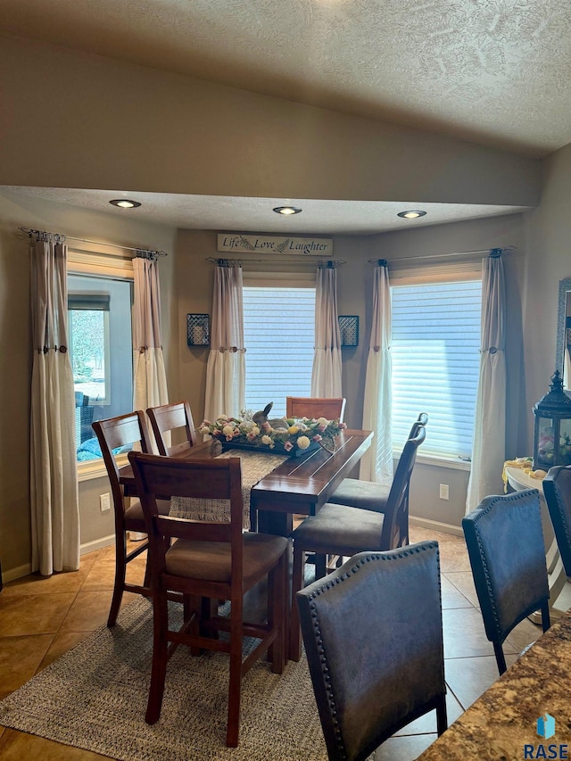 dining room with light tile patterned floors, a textured ceiling, recessed lighting, and baseboards