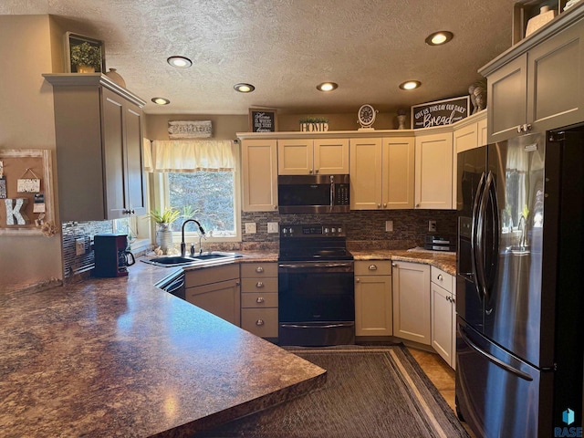 kitchen with dark countertops, appliances with stainless steel finishes, decorative backsplash, and a sink