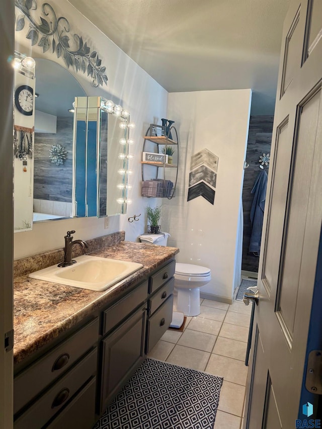 bathroom with toilet, tile patterned flooring, and vanity