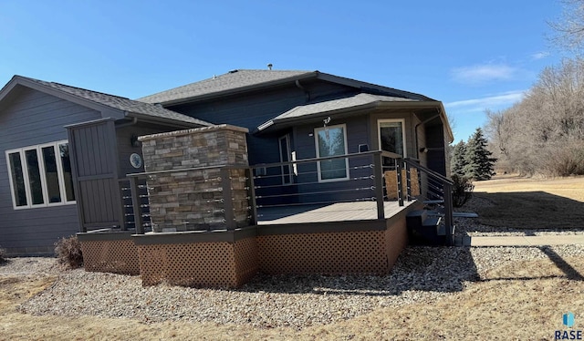 view of front facade with a shingled roof and a deck